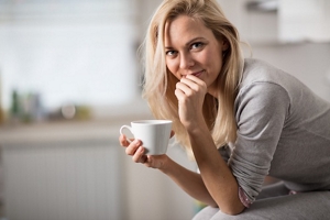 Blonde woman with fine hair having a coffee break